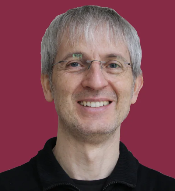 Stephan Kratzert, Klavierlehrer, Portrait mit Brille vor pink-rotem Hintergrund