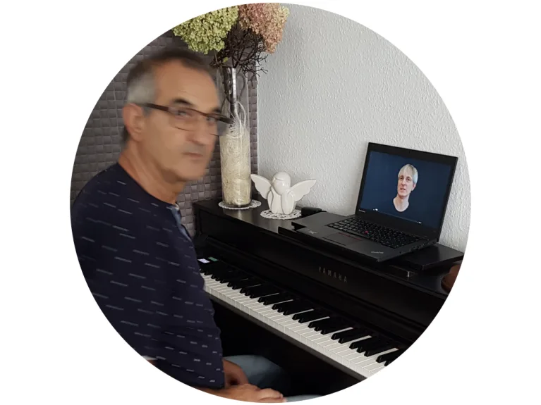 Mann beim Online-Klavierunterricht mit Videocall auf Laptop