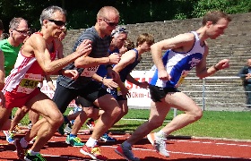 Läufer beim Start eines Rennens auf Tartanbahn, dynamisches Wettkampfbild
