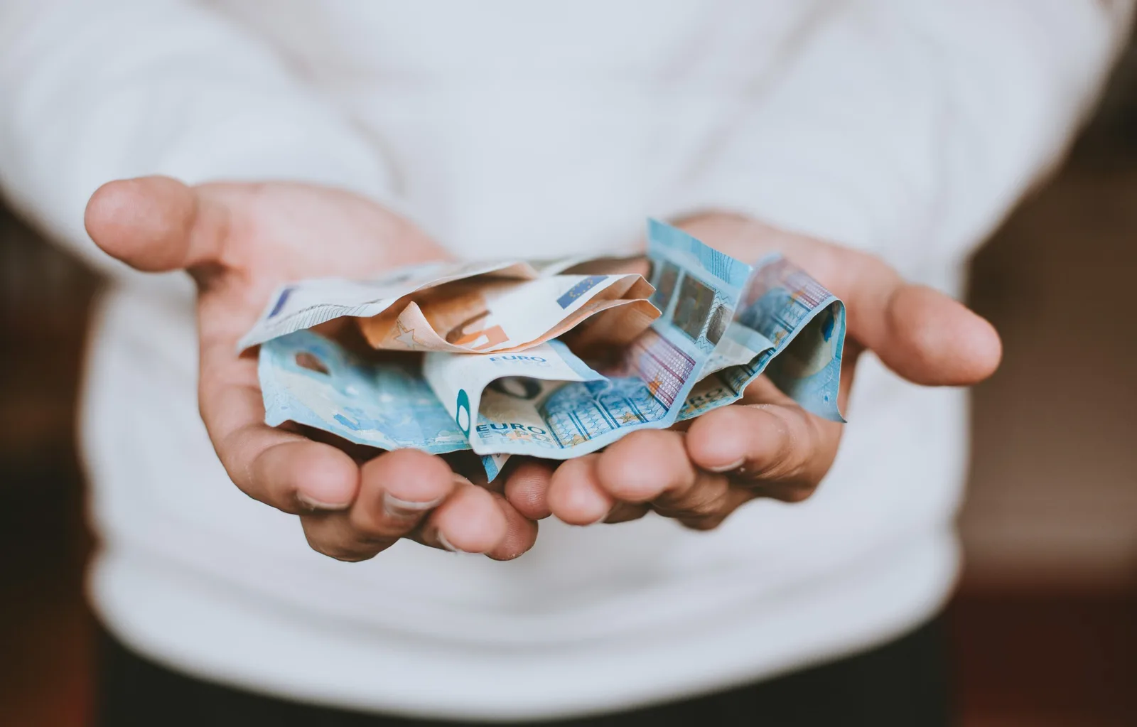 Praxisorientierter Affiliate-Marketing-Leitfaden von Heiko Boos 3 Hände halten Euro Geldscheine zur Darstellung von Affiliate Provisionen