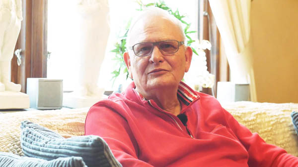 Lars Peter R., Rentner, lacht im Schnee in schwarzer Winterjacke