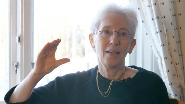 Ruth Bosshard, Jugendpsychiaterin, mit Brille und Halskette am Fenster
