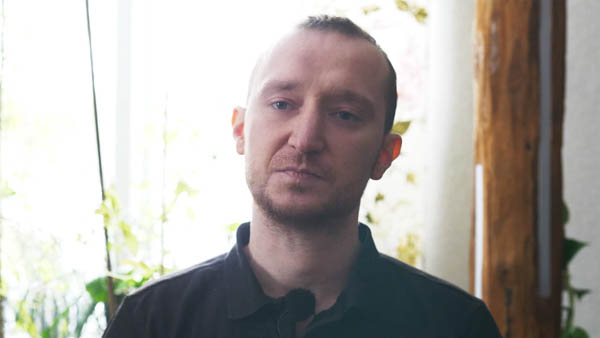 Robert K., Handwerker, mit verschränkten Armen vor Werkzeugwand
