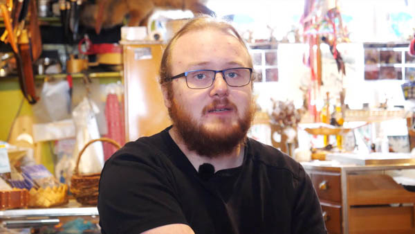Porträt eines Mannes mit Brille in Werkstatt mit Werkzeugen und Materialien