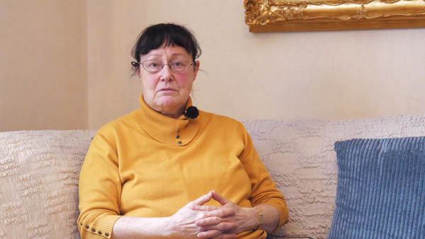 Frau in traditioneller Sami-Kleidung vor schneebedecktem Berg in Norwegen