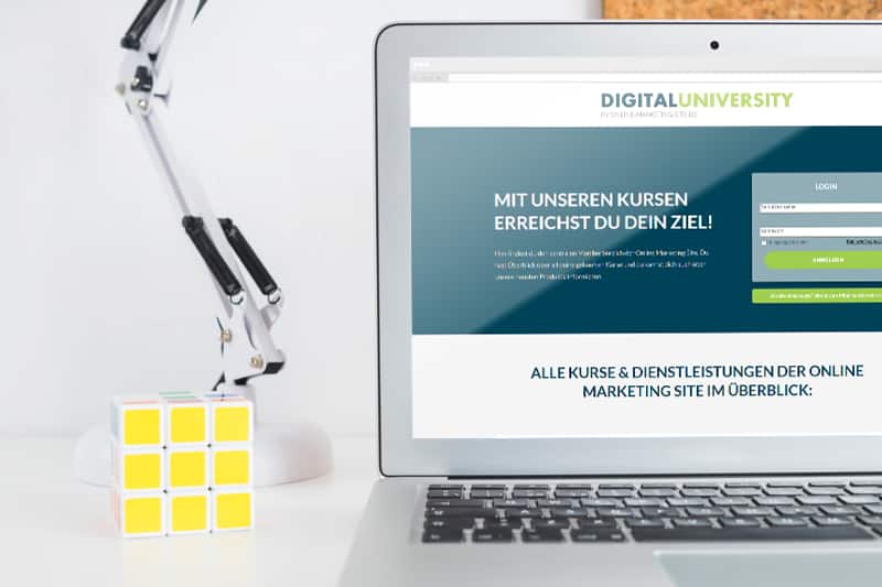 Digitaluniversity Website auf Laptop mit Schreibtisch-Setup und gelben Notizzetteln, Kurse und Dienstleistungen