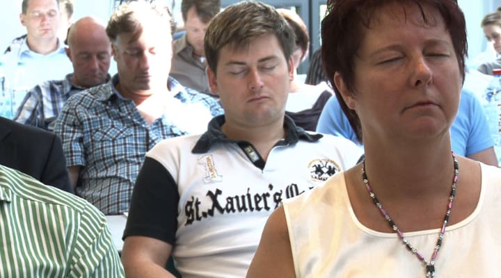 Seminar-Teilnehmer in fokussiertem Zustand während Hypnose-Session