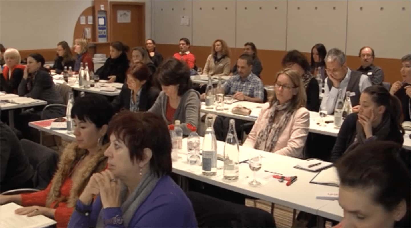 Seminar mit vielen Teilnehmern an Tischen sitzend, Title Prüfungsangst überwinden