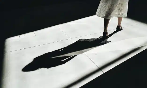 Frau mit langem Schatten auf hellem Boden, Konzept für Innenschau und Schattenarbeit