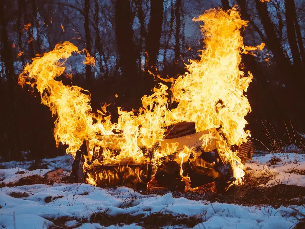 Großes Feuer in Schneewald bei Dämmerung, Wintersonnenwende Yule
