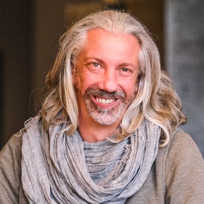 Porträt Marc Intert mit langen grauen Haaren und Schal