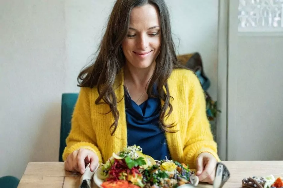 Frau in gelbem Cardigan mit frischem Salat, Entgiftungsthema
