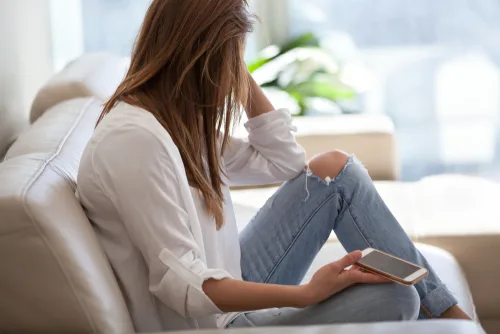 ReConnect Factor 2.0 – E-Book zum Ex-Zurückgewinnen von Marko Slusarek 6 Frau sitzt auf Sofa mit Smartphone, moderne Kommunikation und Verbindung