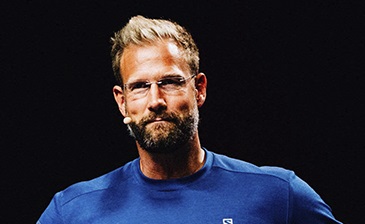 Porträtfoto von Christian Bischoff, blonder Mann mit Bart im blauen Shirt