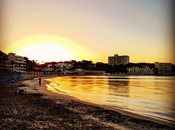 Playa Palmira Strand bei Morgensonne mit Badegästen, goldenem Licht und Küstenblick