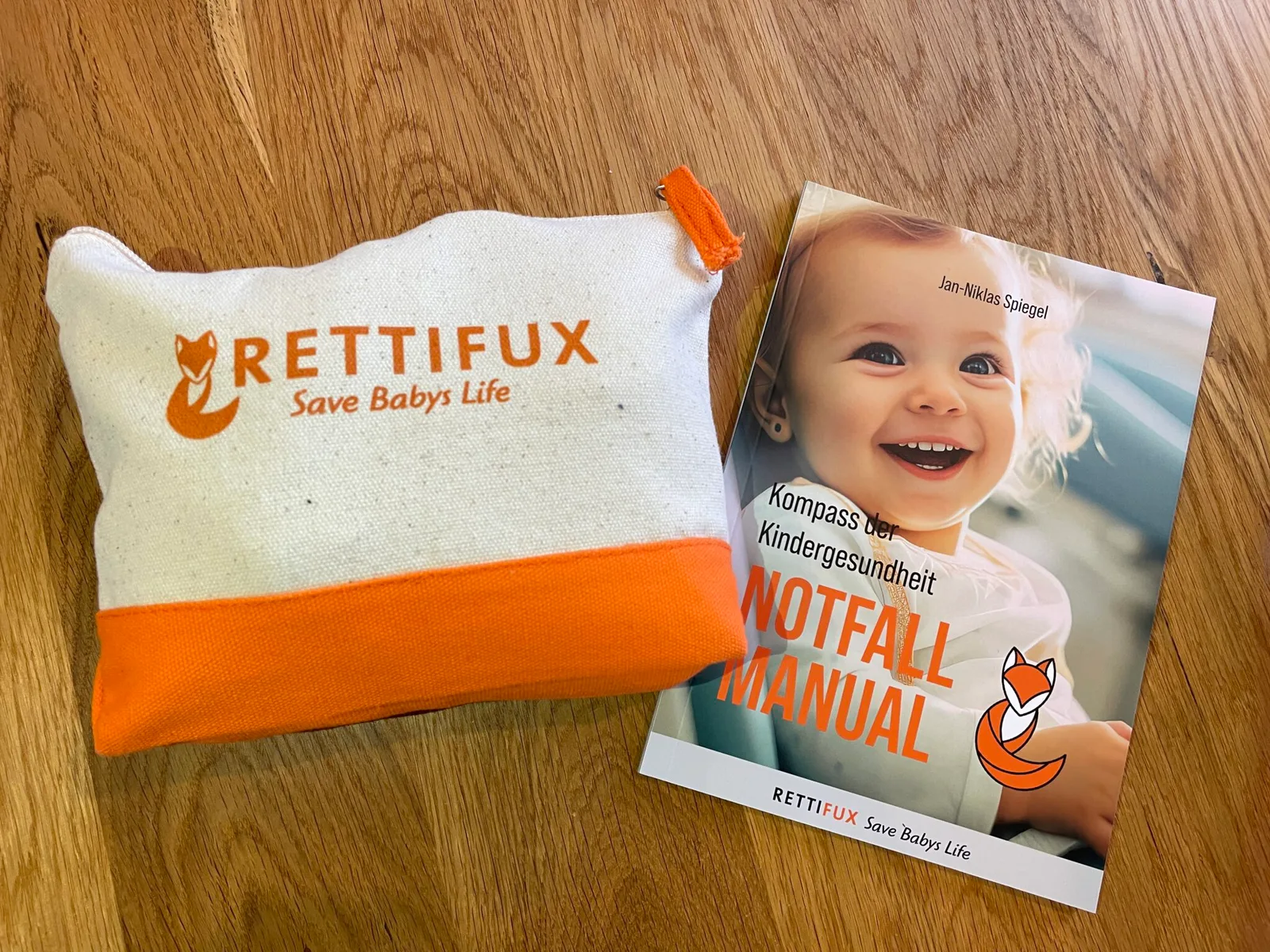 Rettifux Bundle Mockup mit Stoff-Utensilo und Notfall Manual Buch auf Holzoberfläche