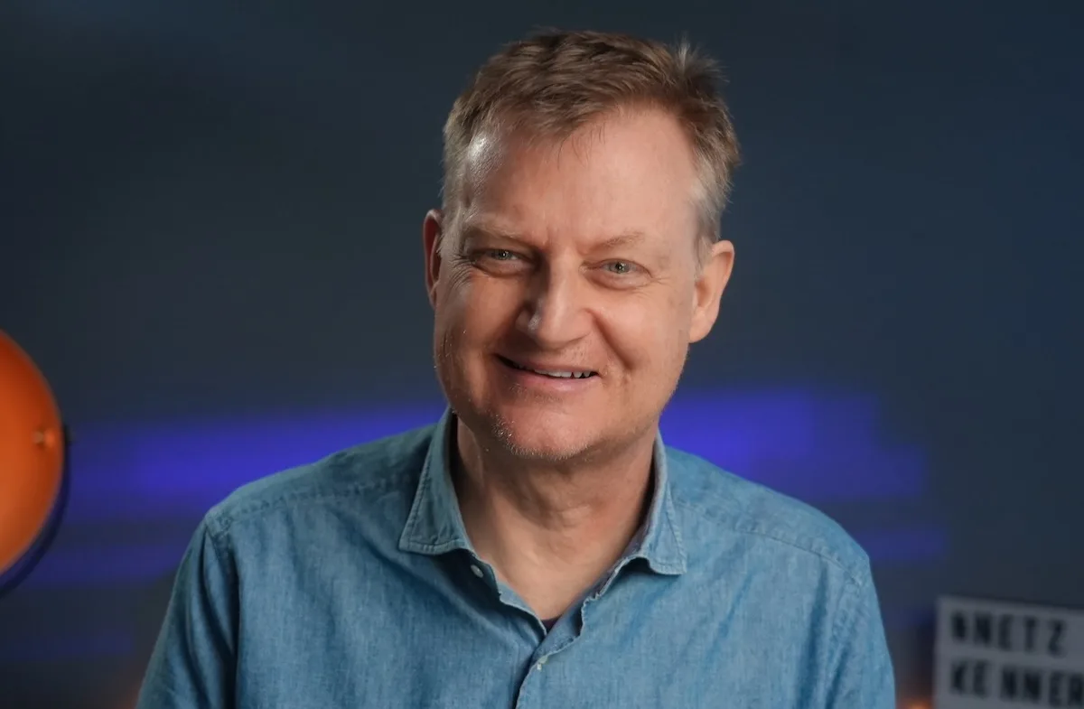 Porträt von Jörg Schieb, Digitalexperte, vor blauem Hintergrund