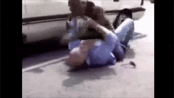 Videostandbild einer Person, die auf dem Boden liegt während andere Personen zuschauen