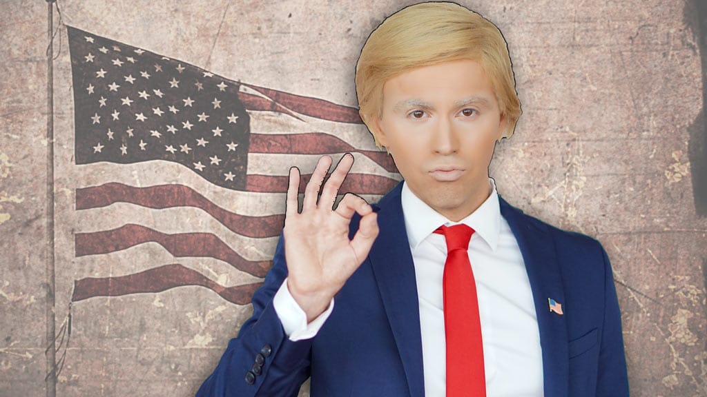 Mann mit Trump-Frisur und roter Krawatte vor amerikanischer Flagge