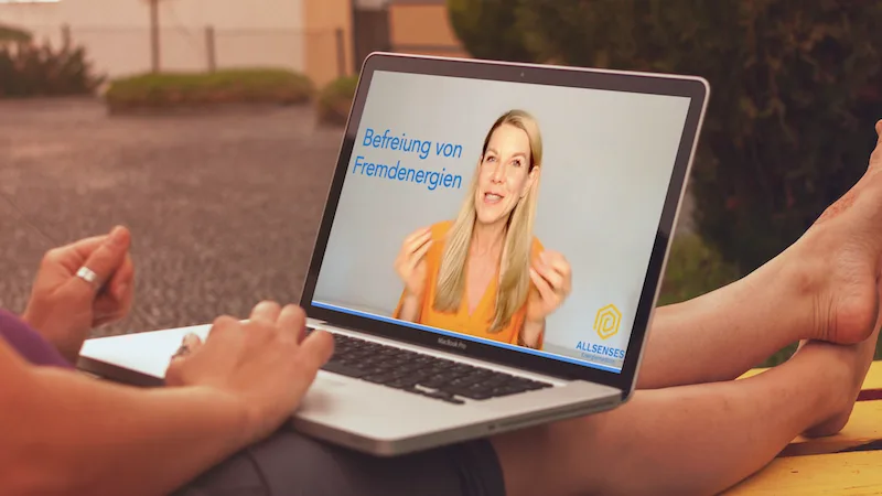 Mockup Laptop mit Frau in orangem Blazer, Titel Befreiung von Fremdenergien