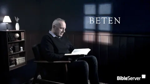 Mann liest in Buch an Schreibtisch, neon-weißer Text Beten mit BibleServer-Logo