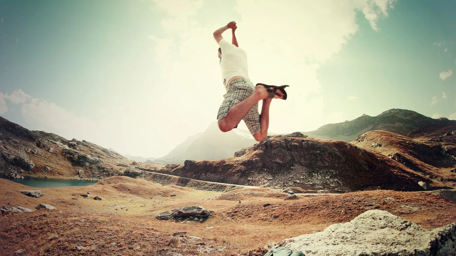 Mann macht Salto in Berglandschaft