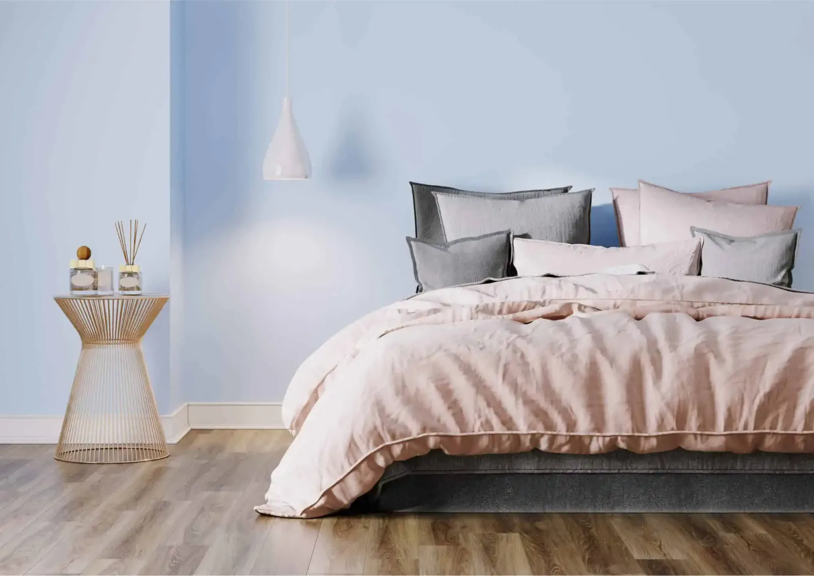 Modern eingerichttes Schlafzimmer mit beigem Bettzeug, Holzboden, Nachttisch mit Dekoration