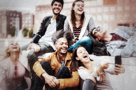 Gruppe von fünf lachenden Menschen verschiedener Ethnien, die gemeinsam ein Selfie machen