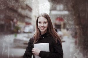 Junge Frau mit Tablet in schwarzer Jacke in Bukarest