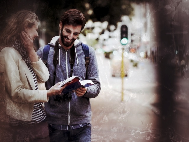 Junges Paar schaut auf Smartphone und Karte während Stadtrallye in der Stadt
