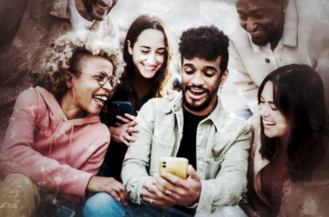 Diverse Gruppe von sechs Personen lächelnd mit Smartphone beim Teamwettbewerb