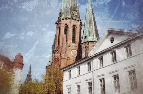 Kirche mit rötlichem Mauerwerk und grüner Turmspitze in der Oldenburger Altstadt
