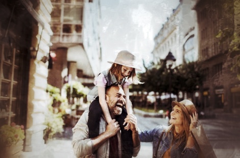 Familie mit Kind und Vater im Innenhof, entdeckend und lachend während Stadtrallye