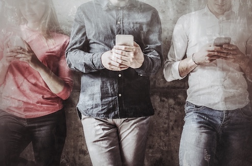 Vier Personen halten Smartphones in den Händen während einer Stadtrallye