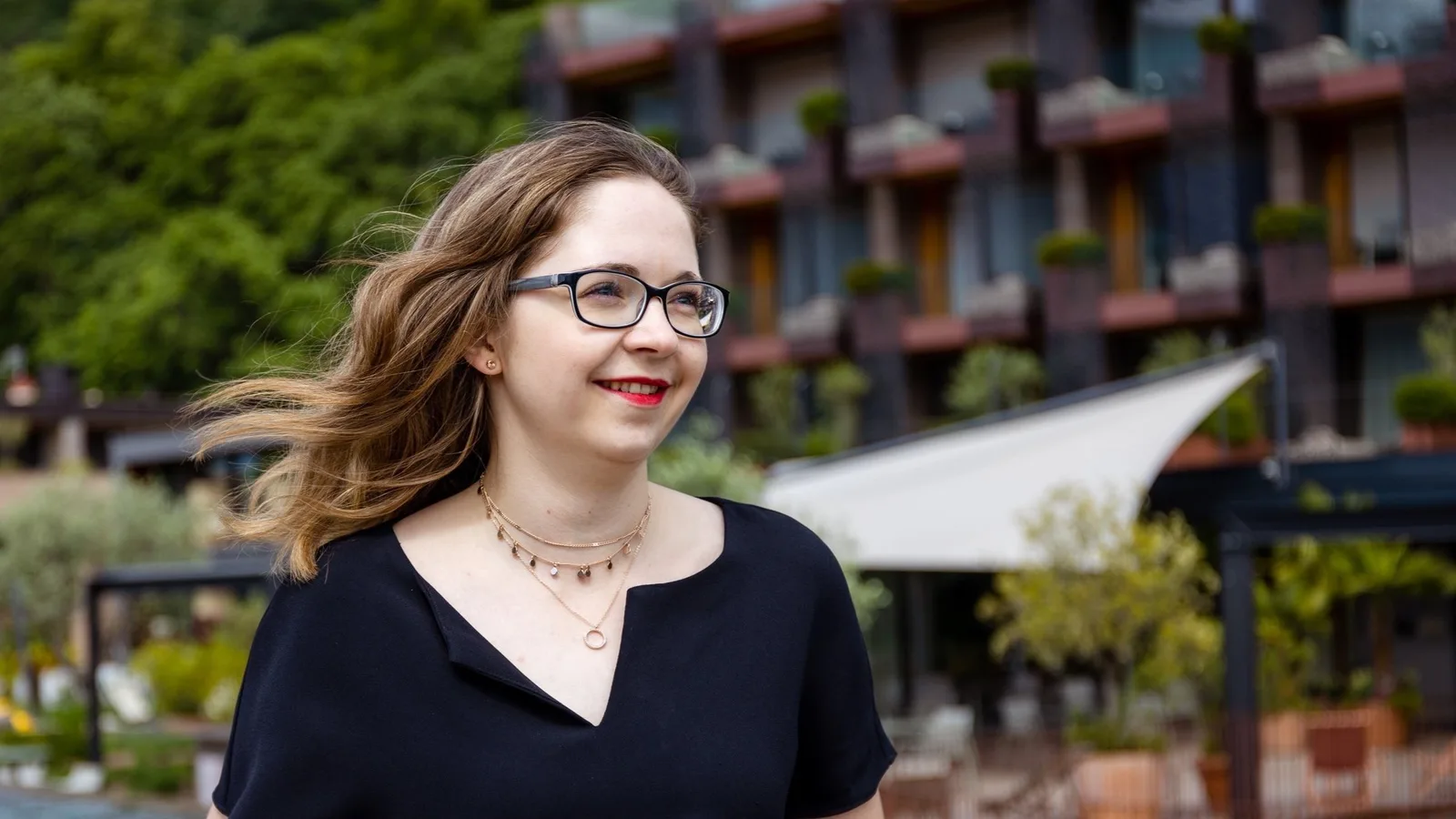 Selflove Vibes – Onlinekurs für mehr Selbstwert von Marie Kremer 6 Marie Kremer Porträt im Freien blickend nach links, schwarzes Shirt, Schmuck, grüner Hintergrund