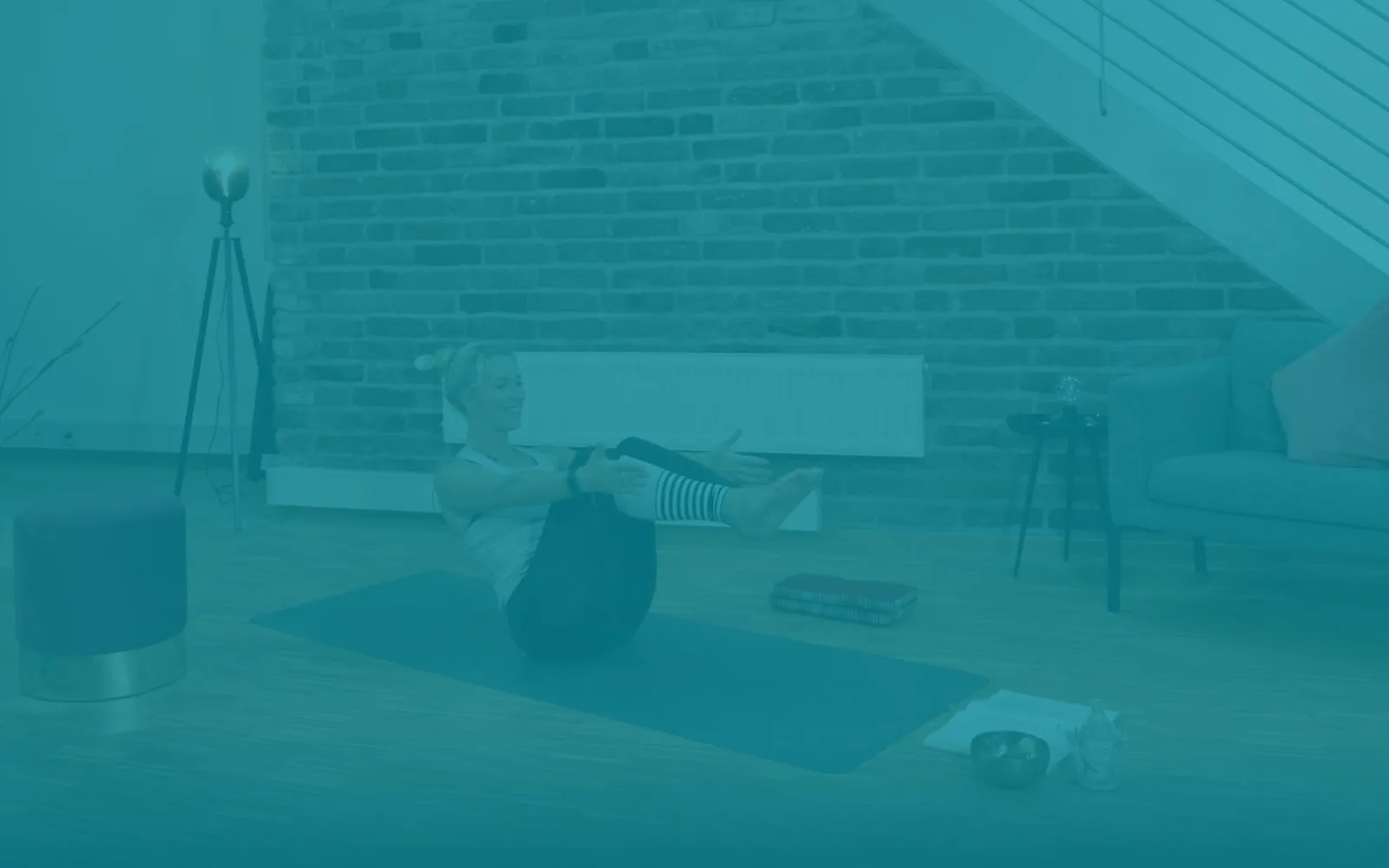 Frau beim Home-Training auf Matte in Loftwohnung mit Backsteinwand, Teal-Overlay