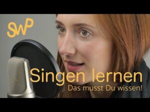 Frau singt ins Studiomikrofon mit Text Singen lernen Das musst Du wissen