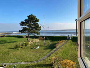 Sinn im Leben finden – Live-Workshop zur Resilienz von Anke Lüneburg 1 Ausblick auf Wasser und Grünfläche mit Baum und Kreuz an der Küste