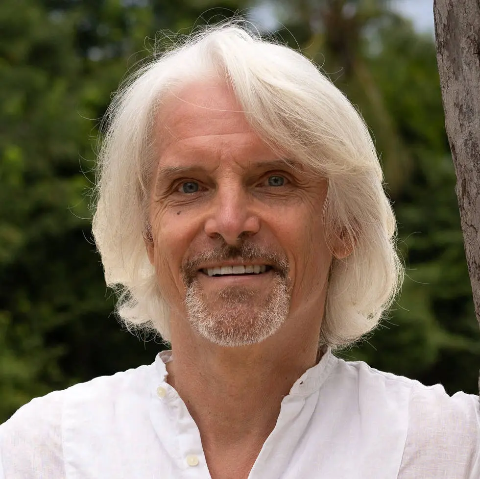 Porträt von Michael Wieden mit weißem Hemd vor grünem Hintergrund im Freien