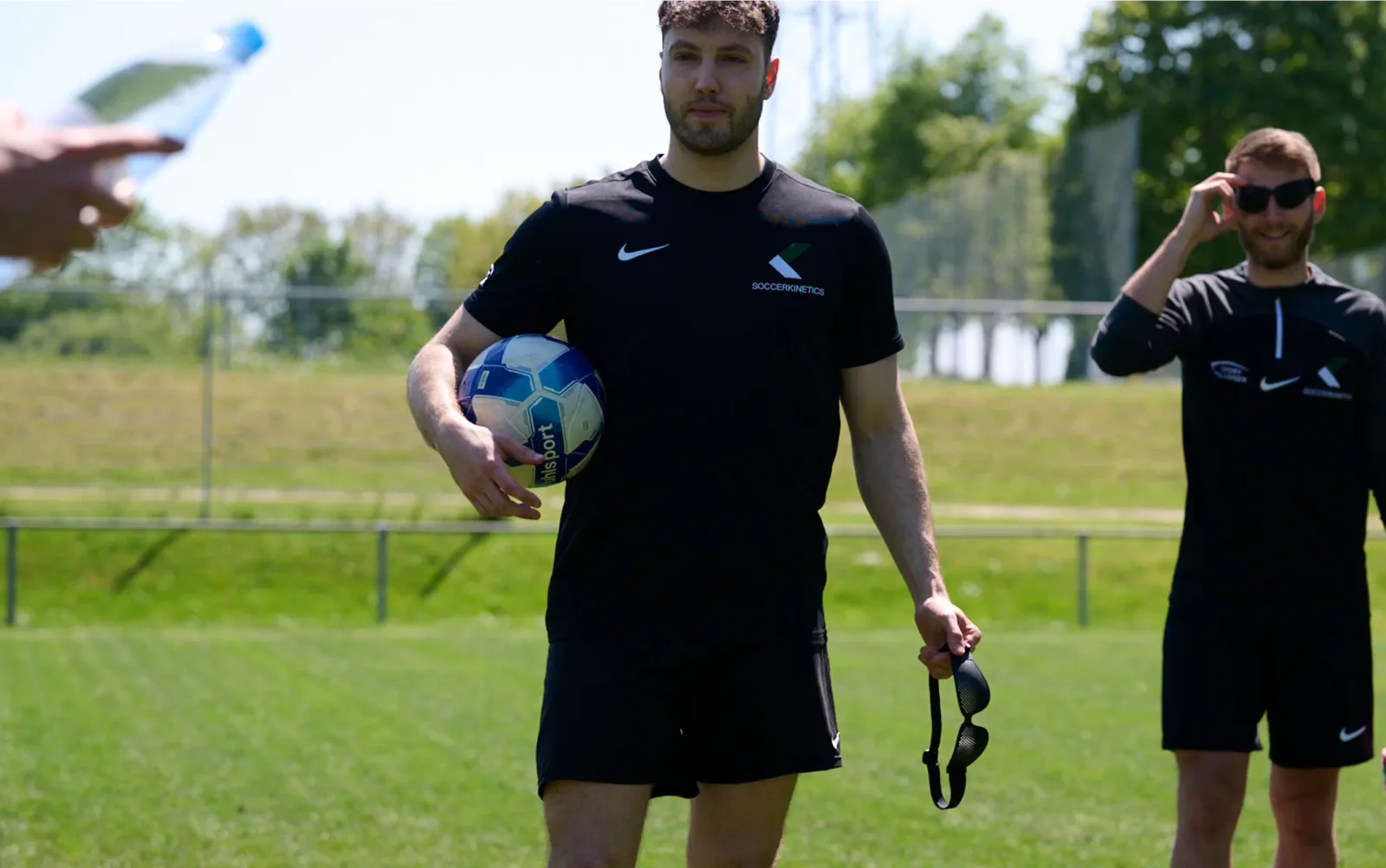 Trainer und Spieler mit Soccerkinetics Ausrüstung auf dem Trainingsplatz