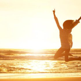 Sommer-Sonnenwende 2026 – Live-Webinar zur Energiearbeit 11 Frau mit erhobenen Armen am Strand bei Sonnenaufgang, Lebensfilm gestalten