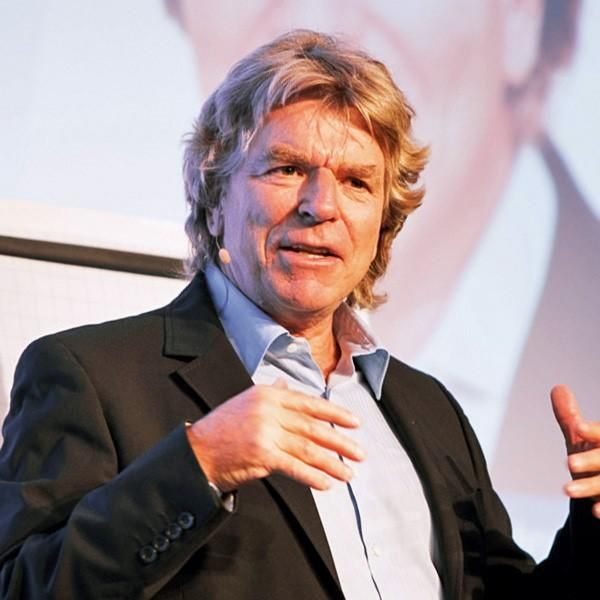 Porträt von Dieter Lange, Mann mittleren Alters mit Haaren und Bart im dunklen Blazer auf Bühne