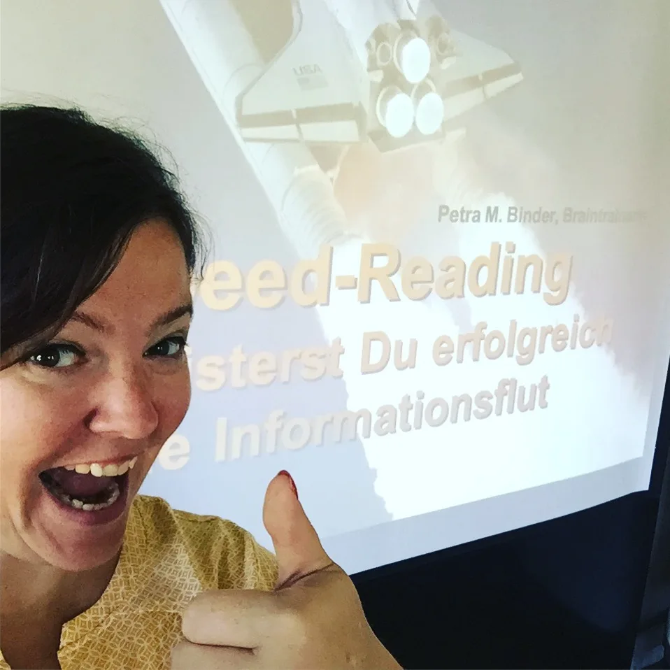 Frau mit Daumen hoch vor Speed-Reading-Präsentation mit Petra M. Binder