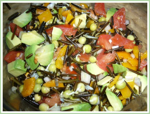Wildreissalat mit Gurke Tomate Mais und Sprossen gemischt auf Holzuntergrund