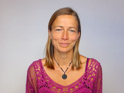 Porträt einer Frau mit langen Haaren in pink-lilafarbener Bluse