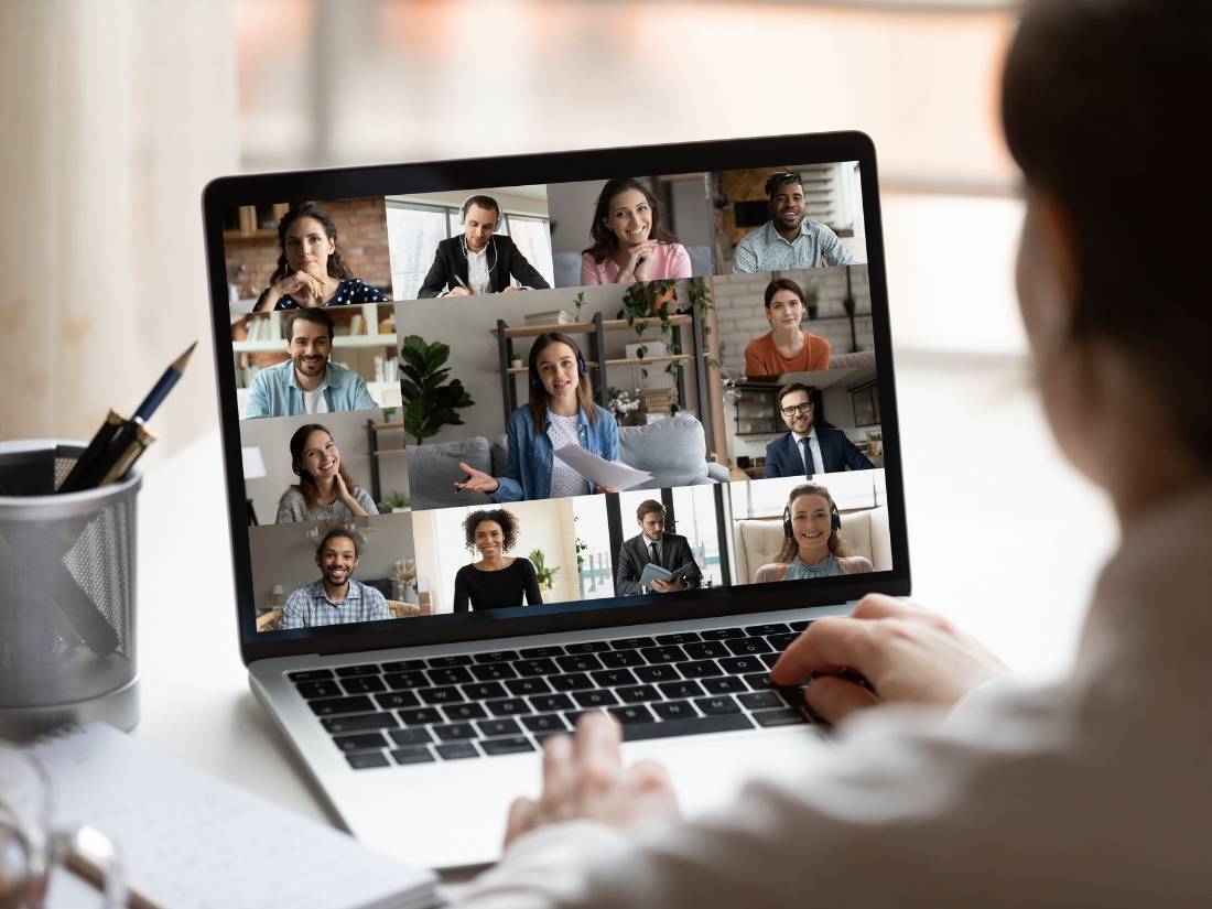 Videokonferenz auf Laptop-Bildschirm mit 16 Teilnehmern in verschiedenen Kacheln