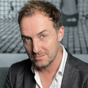 Porträtfoto von Dirk Hilger vor grauem Hintergrund