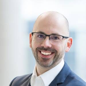 Porträtfoto von Heiko Behrendt mit Brille und Business-Kleidung