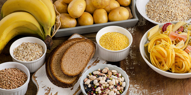 Verschiedene kohlenhydratreiche Lebensmittel wie Bananen, Brot, Nudeln und Getreide