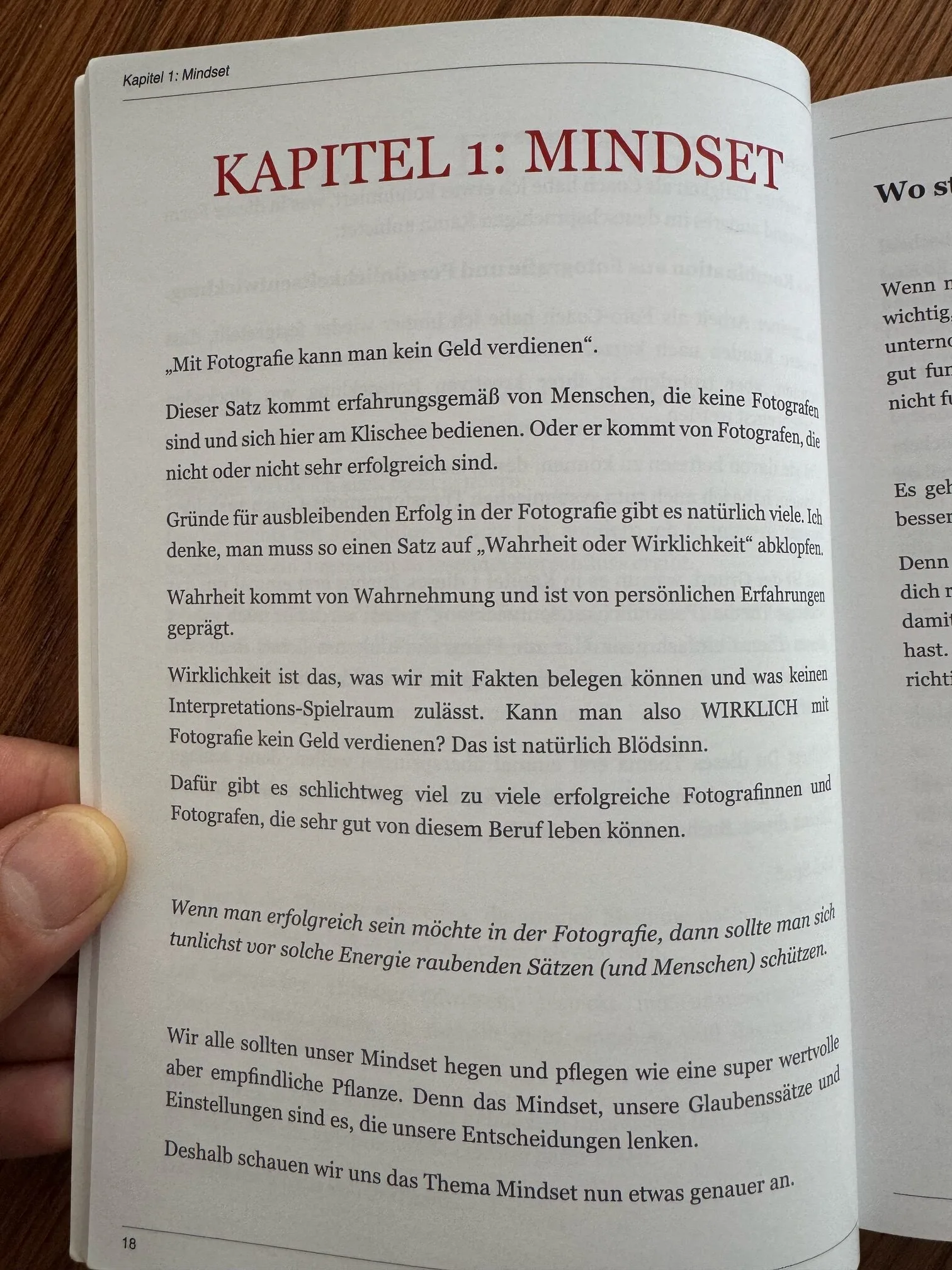Buchseite mit Überschrift Kapitel 1: Mindset, Text über Fotografie und verdientes Geld, auf Holzoberfläche